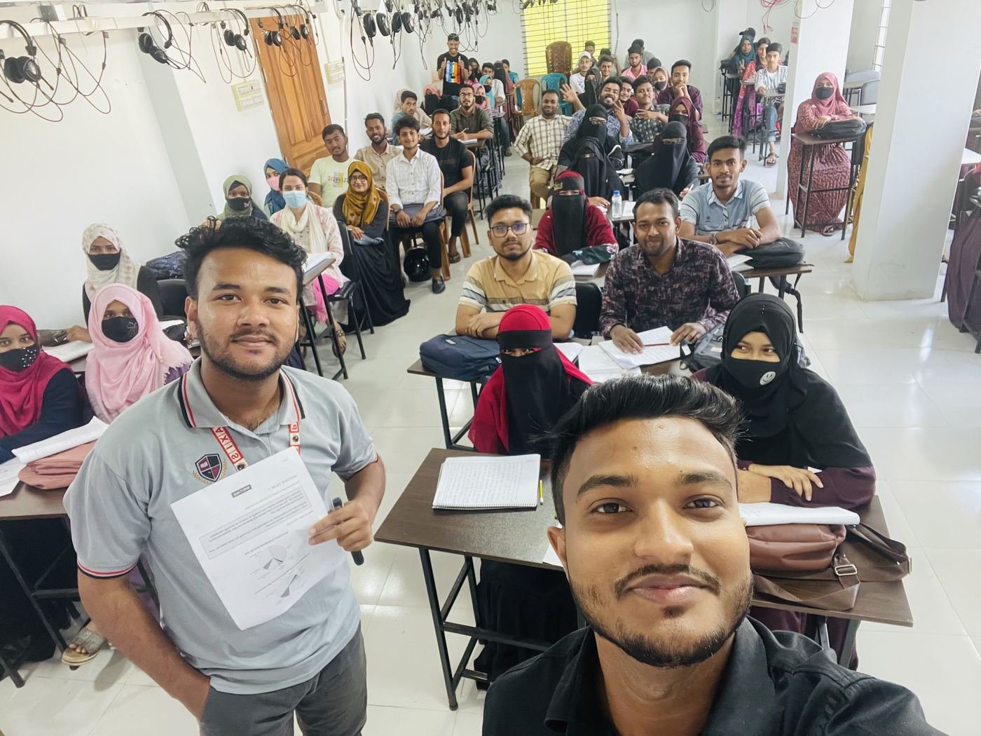 A full class of Praxis students smiling for a selfie with their instructor